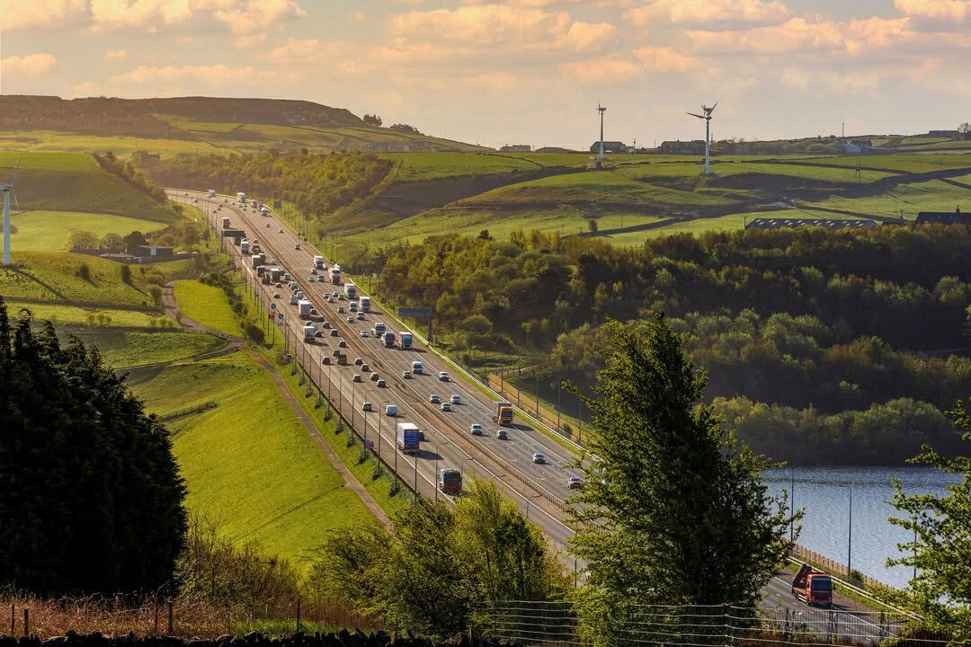 The M62 through the Pennines, with roadside woodland either side of the carriageway